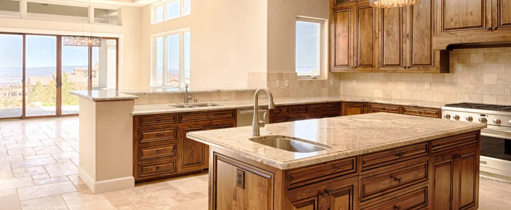 Finished custom kitchen with wood cabinetry and stone counters